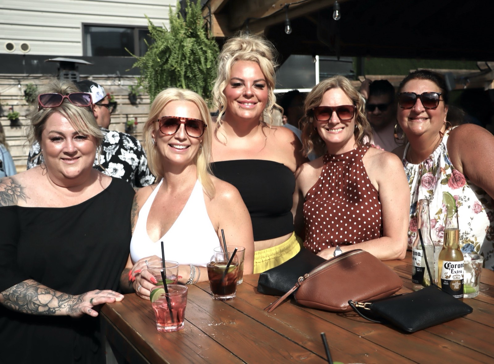 A group of friends gathered around the bar table with drinks in hand